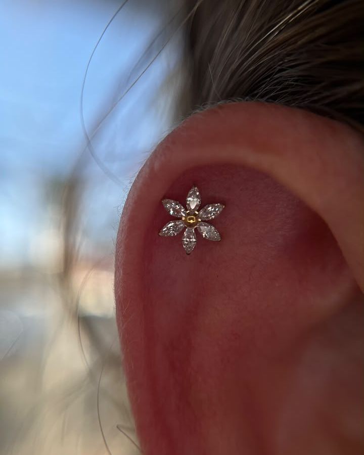 Piercing na orelha com joia em formato de flor
