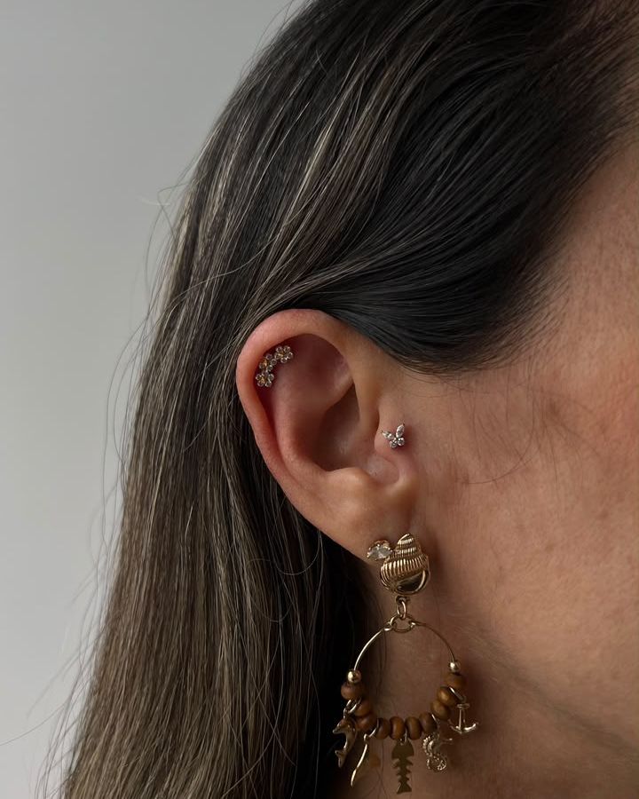 Piercing na orelha com joia dourada